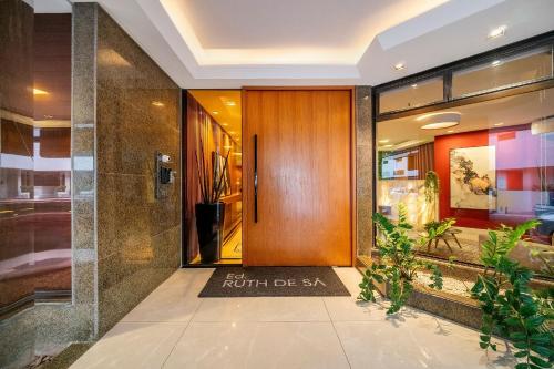 a lobby with a wooden door in a building at Ruth de Sá 3 Dorm Quadra Mar by Achei Camboriú in Balneário Camboriú