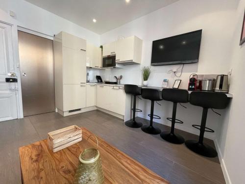 Il comprend une cuisine avec un bar et une télévision murale. dans l'établissement C039-APPARTEMENt LUMINEUX AU SUQUET POUR 3 PERSONNES, à Cannes