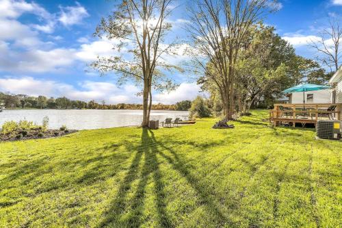 a yard with a tree and a house and a lake at Hidn LakeFront-New Build-Private Beach-Fast Wi-Fi in Brighton
