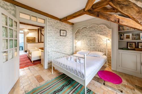 une chambre avec un lit et un mur de briques dans l'établissement Les Rangeardières - Piscine - Familial, à Saint-Barthélemy-dʼAnjou