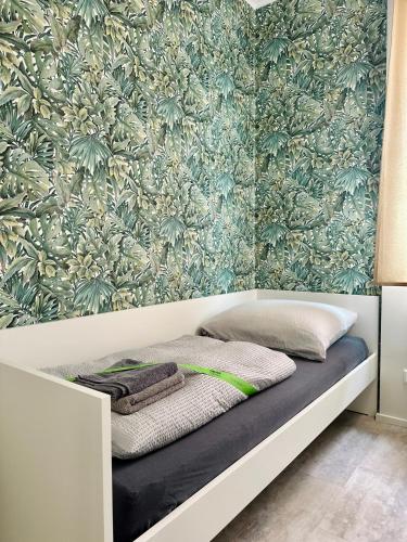 a bed in a room with a floral wallpaper at Neuwertiges Apartment mit schnellem WLAN, Glasfaser, R7 in Freiberg am Neckar