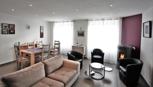 un salon avec un canapé, une table et des chaises dans l'établissement IROISE GRANDE MAISON en Baie d'Audierne Finistère 5 chambres, à Plozévet