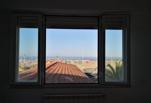 a window in a room with a view of a roof at Appartamento Passeggiata Vista Mare in Viareggio