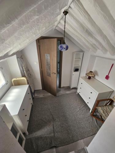 an attic room with a desk and a door at Le petit paradis de Nicole in Villanueva de Algaidas