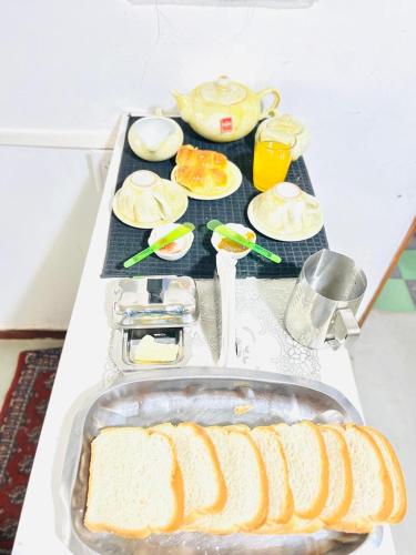 een tafel met brood en borden voedsel erop. bij Hostel La Juana - Ezeiza - in Ezeiza
