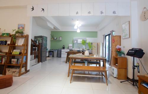 a room with a table and chairs and a kitchen at 出水茶旅民宿 in Zhuqi