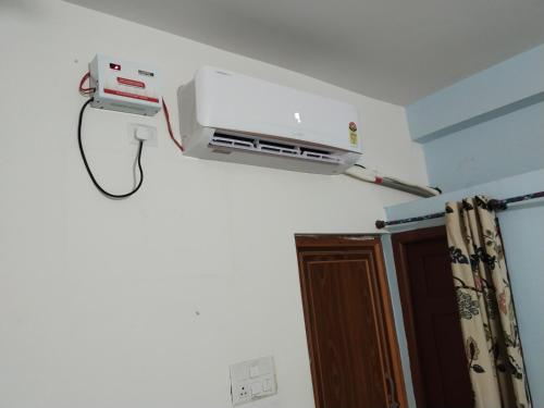 a hair dryer is on the wall of a room at Sunny Homestay in Silchar