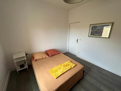 une chambre avec un lit avec une couverture jaune dessus dans l'établissement Chez Thibaud, à Frontignan