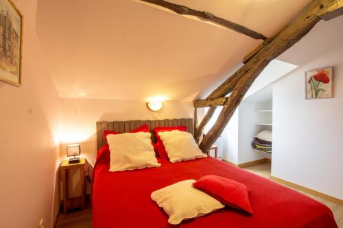 a bedroom with a red bed with two pillows at Moulin neuf de combecave in Saint-Amand-de-Vergt