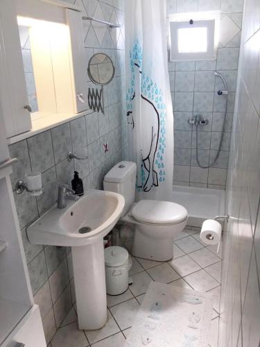 a bathroom with a toilet and a sink and a shower at Arillas view 1 in Kefalári