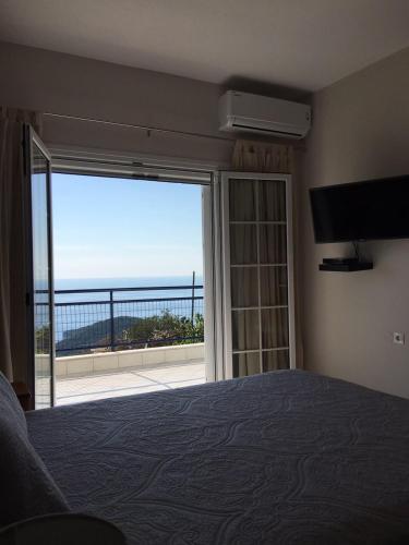 a bedroom with a bed and a view of the ocean at Arillas view 1 in Kefalári