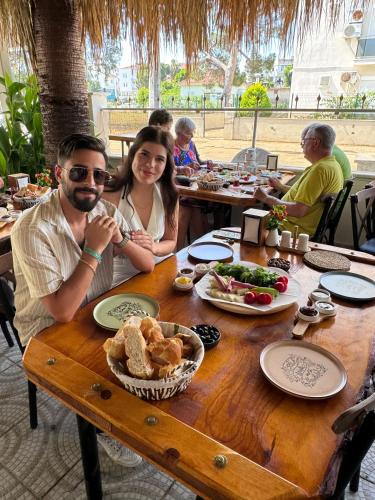 a man and woman sitting at a table with food at BELKA GOLF RESİDENCE Poolside apt1 Belek in Belek