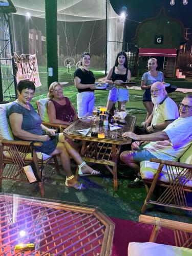a group of people are sitting around a table at BELKA GOLF RESİDENCE Poolside apt1 Belek in Belek