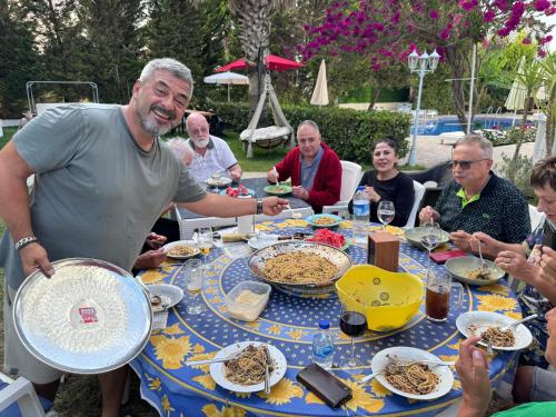 a group of people sitting around a table eating food at BELKA GOLF RESİDENCE Poolside apt1 Belek in Belek