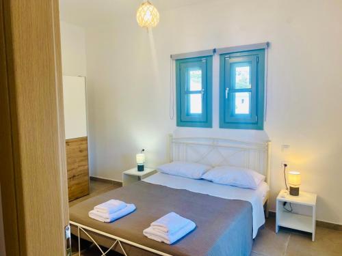 a bedroom with a bed with two towels on it at Sophia's Apartments - Lipsi Rosemary in Lipsoi