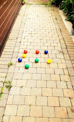 a group of colorful balls on a brick sidewalk at Chalet 176, Durbuy PROMO in Durbuy