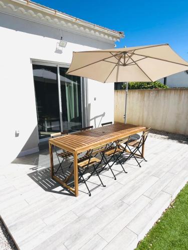 - une table et des chaises en bois avec un parasol sur la terrasse dans l'établissement villa cooper, à La Seyne-sur-Mer