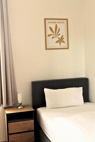 a bedroom with a bed and a picture on the wall at Hotel Fokus in Emsbüren