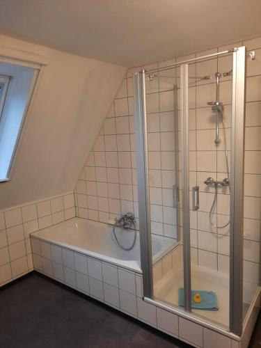 a bathroom with a bath tub and a shower at Landgasthof May in Willanzheim