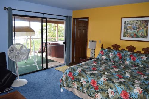 a bedroom with a bed and a sliding glass door at A Beautiful Edge of the World Bed & Breakfast in Captain Cook
