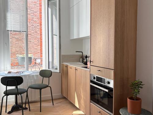 eine Küche mit einem Tisch und 2 Hockern in der Unterkunft Home Chic Home - Le Cocon de Paris La Défense in La Garenne-Colombes