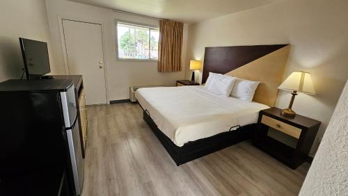 a hotel room with a bed and a television at Budget Inn in Williamsburg