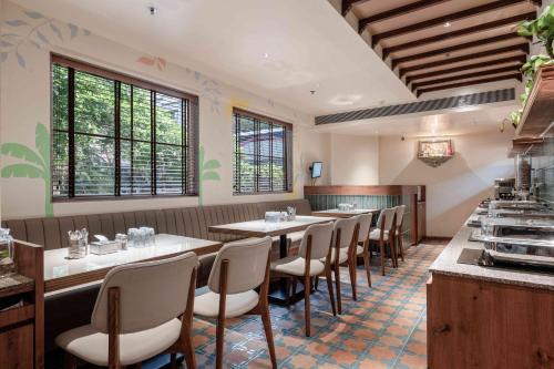 a restaurant with a row of tables and chairs at Nine Square Residency in Jāmb