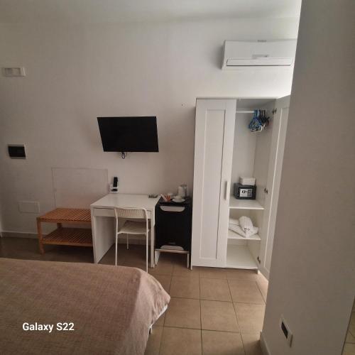 a room with a bed and a desk with a television at Casale Marcalia - bed & breakfast in Corigliano Calabro