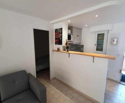 un salon avec un canapé et une cuisine dans l'établissement 3 pièces au calme Terrasses Piscine et Tennis Garage, à Cagnes-sur-Mer