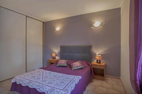 - une chambre avec un lit violet et 2 oreillers dans l'établissement Maison cosy près de Pietracorbara avec piscine, à Pietracorbara