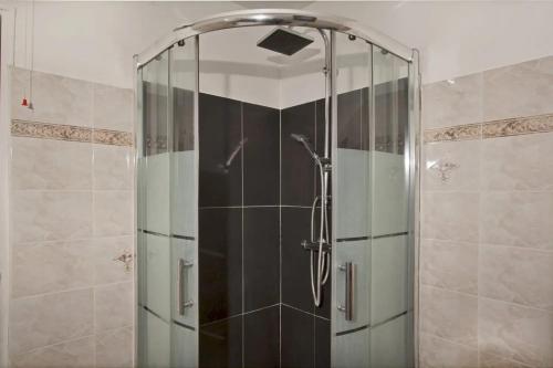 une douche avec une porte vitrée dans une salle de bain dans l'établissement Maison cosy près de Pietracorbara avec piscine, à Pietracorbara