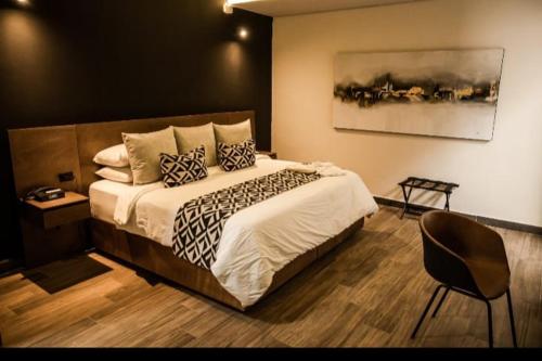 a bedroom with a large bed and a chair at Esplendor by Wyndham San Luis Potosi in San Luis Potosí