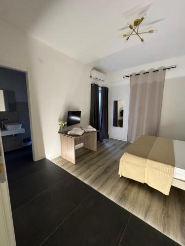 a bedroom with a bed and a desk and a television at The Better in San Giorgio a Cremano