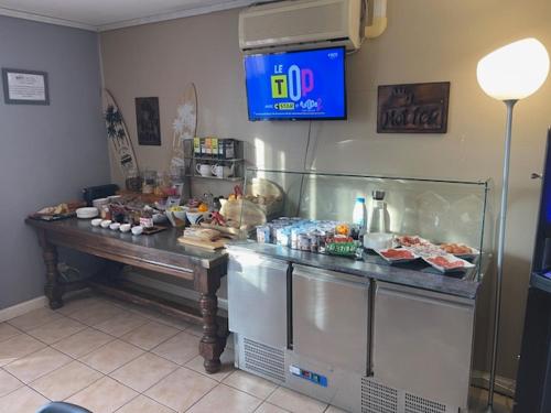 a food counter in a restaurant with food on it at Brit Hotel Essentiel Pau Lescar in Lescar
