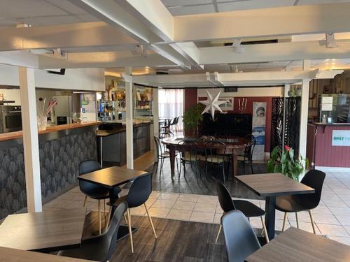 a restaurant with tables and chairs in a room at Brit Hotel Essentiel Pau Lescar in Lescar