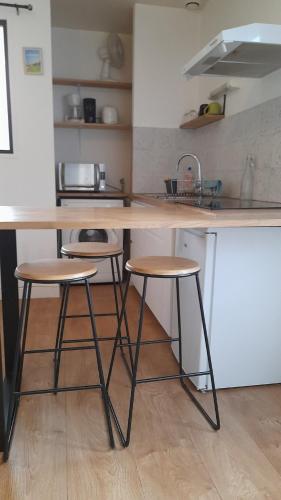 une cuisine avec deux tabourets de bar et un comptoir dans l'établissement Studio 3 people Maritime Museum La Rochelle, à La Rochelle