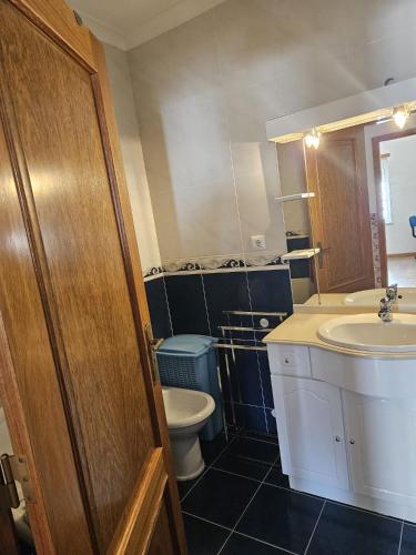 a bathroom with a toilet and a sink at BigWaves2 in Nazaré