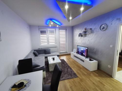 a living room with a couch and a tv at Stan na dan, Istocno Sarajevo, 2 spavace sobe in Vranješ