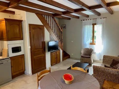 un salon avec une table et une cuisine dans l'établissement Appartement familial à Pietracorbara avec piscine, à Pietracorbara