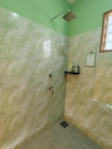 a bathroom with a shower with a glass door at Hijau Harmoni Stay in Mersing
