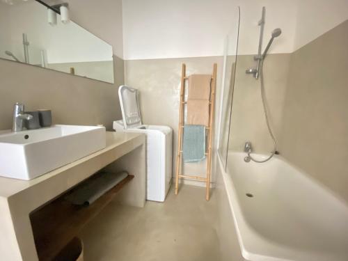 une salle de bain blanche avec un lavabo et une baignoire dans l'établissement T3 plein centre de Sanary, à Sanary-sur-Mer