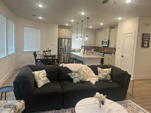 a living room with a couch and a kitchen at The Clement Chateau - Brand New Home in Missouri City