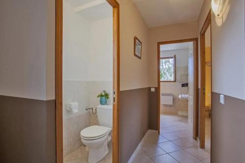 une salle de bain avec toilettes et lavabo dans l'établissement Maison familiale avec piscine à Pietracorbara, à Pietracorbara