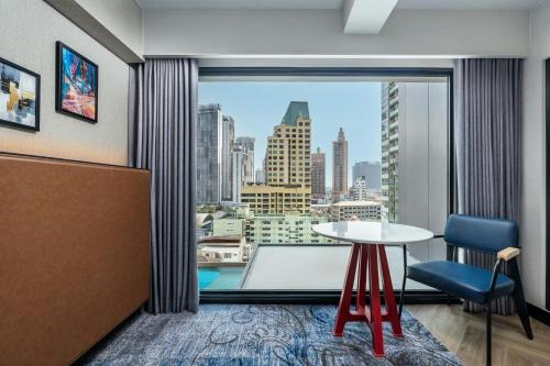 a room with a table and a large window at Four Points by Sheraton Bangkok, Sukhumvit 22 in Bangkok