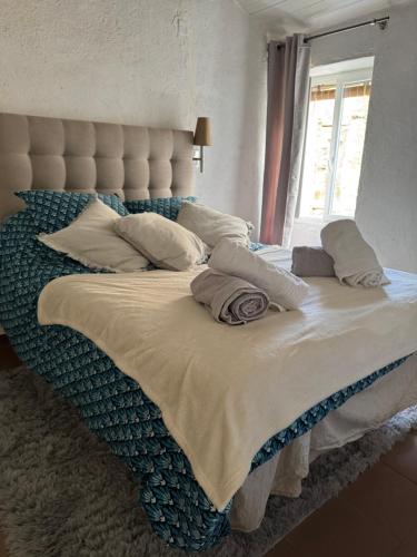 - un grand lit avec des oreillers dans la chambre dans l'établissement Joli T2 in Cap Corse, à Ersa