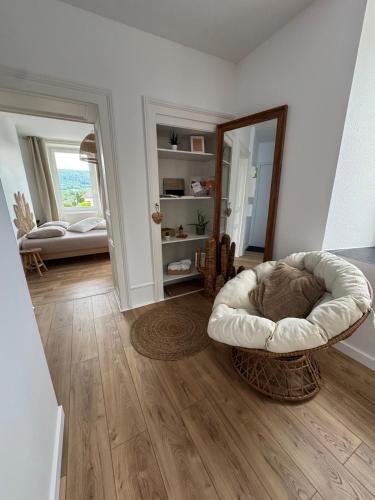 a living room with a chair and a mirror at Escapade bohème in Blamont