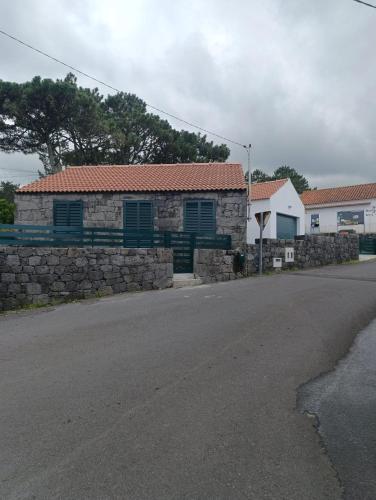 a house with a stone wall and a street at Casa da Miragaia in Maragaia