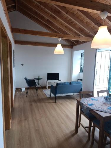 a living room with a blue couch and a tv at Casa da Miragaia in Maragaia
