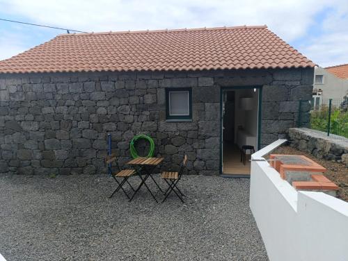 a stone house with a table and chairs in front of it at Casa da Miragaia in Maragaia