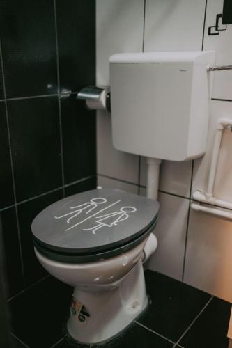 a bathroom with a toilet with writing on the lid at Villa Yajima in Predeluţ